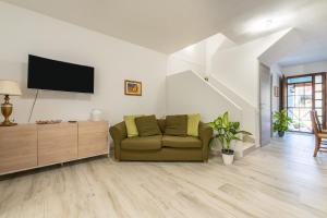 a living room with a couch and a flat screen tv at Casa vacanze Elifra in San Giovanni Suergiu