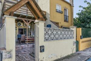 an entrance to a house with a wooden pergola at Casa entera Empuriabrava y terraza in Empuriabrava