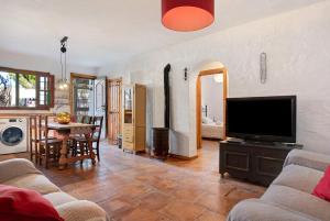 a living room with a television and a dining room at Casa Ohanna in Vejer de la Frontera