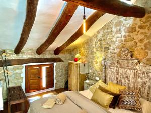a bedroom with a bed and a stone wall at La Casuna in Olba