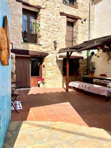 an outdoor patio with a stone building with a bench at La Casuna in Olba