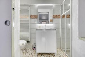 a white bathroom with a sink and a toilet at Le Clos Rilda en Bounet in Villefranche-de-Lauragais +23 photos