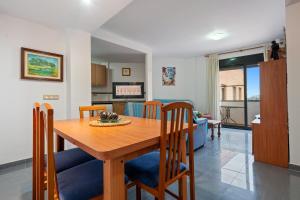 a kitchen and dining room with a wooden table and chairs at Deltebre riu in Deltebre
