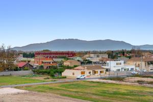a small town with houses and a car on a road at Deltebre riu in Deltebre