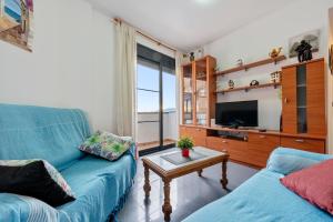 a living room with a blue couch and a tv at Deltebre riu in Deltebre