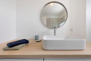 a bathroom with a white sink and a mirror at Les terrasses de Kerhos in Camaret-sur-Mer +13 photos