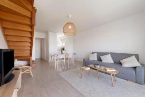 a living room with a blue couch and a table at Les terrasses de Kerhos in Camaret-sur-Mer
