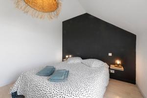 a bedroom with a bed with two blue pillows on it at Les terrasses de Kerhos in Camaret-sur-Mer
