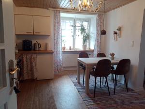 a kitchen with a table and chairs and a window at Kinderfreundlich Am Dorflädchen in Blankenheim +2 photos