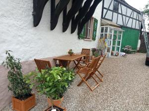 a patio with a wooden table and chairs in front of a building at Kinderfreundlich Am Dorflädchen in Blankenheim