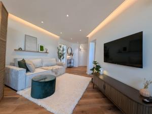 a living room with a couch and a flat screen tv at City Apartments Osnabrück - Balkon & Parken inklusive in Osnabrück
