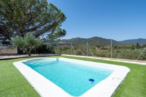 a swimming pool in a yard with green grass at Ca La Cuca in Alforja