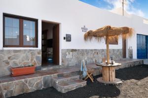 a table with an umbrella next to a building at El rinconcito de Jess in El Golfo
