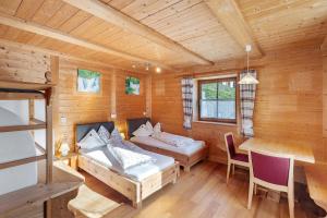 a room with two beds and a table in a cabin at New - Steinhof Val di Mezzo in Val di Mezzo