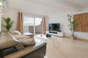 a living room with a couch and a tv at La Perla vista al mar Fabiola 1 in Calpe