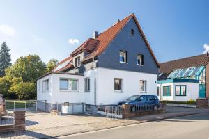 a house with a blue car parked in front of it at Modernes Apartment am Deister in Springe
