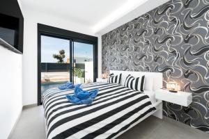 a bedroom with a black and white striped bed and a wall at R-40-B Luxury Villa with pool in Los Montesinos +29 photos