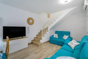 a living room with a blue couch and a tv at Los Arenales al Sol in Arenales del Sol