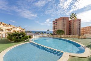 a large swimming pool in a resort with buildings at Los Arenales al Sol in Arenales del Sol