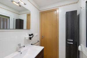 a bathroom with a sink and a wooden door at Casa Menvil in Sant Jordi de Cercs