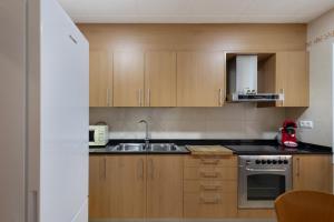 a small kitchen with wooden cabinets and a sink at Casa Menvil in Sant Jordi de Cercs +19 photos