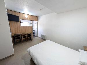 a bedroom with a bed and a table and a television at Class'Eco Namur in Namur