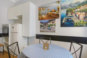 a kitchen with a table and two paintings on the wall at La Casa Del Marinaio in Rapallo