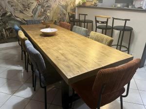 a wooden table with chairs and a bowl on it at Chambre d'hôte Léontine in Lamagistère