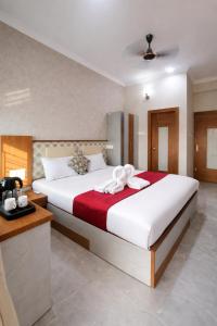 a bedroom with a large bed with a red blanket at Baibhab Convention & Resort in Bhubaneshwar