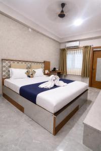 a bedroom with a large bed in a room at Baibhab Convention & Resort in Bhubaneshwar