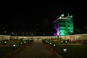a building with green lights on it at night at Baibhab Convention & Resort in Bhubaneshwar