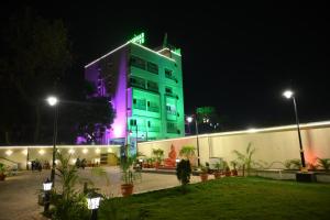 a building lit up in purple and green at night at Baibhab Convention & Resort in Bhubaneshwar