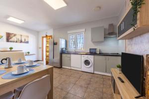 a kitchen with white appliances and a table with chairs at Nazareno in Níjar +13 photos