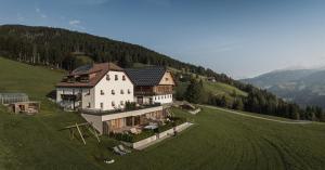 a large house on top of a green hill at Rueper Hof Chalet Ruipa in Valdaora