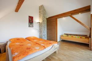 a bedroom with a bed with an orange comforter at I'd Love To Be Home in Bidingen