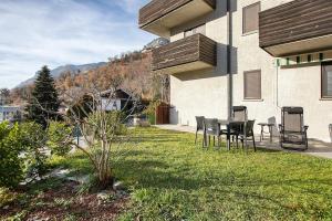 a patio with chairs and a table in a yard at Maison de Doi - Chatillon in Châtillon