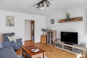 a living room with a couch and a tv at Andis Ferienwohnung in Farchant
