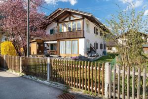 a white house with a wooden fence at Andis Ferienwohnung in Farchant