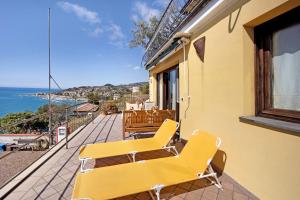 a yellow bench on a balcony with a view of the ocean at Casa Pepe in Imperia
