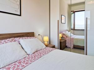 a bedroom with a white bed and a mirror at Porta a Mare Home in Portoferraio