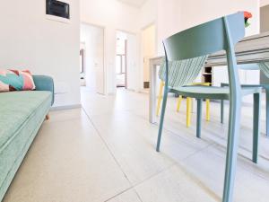 a green chair in a living room with a couch at Porta a Mare Home in Portoferraio