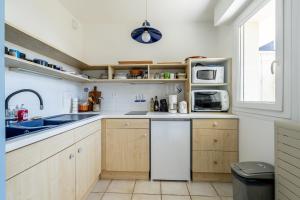 a kitchen with a sink and a microwave at Cap Sur L’océan - 481 in Pornic +16 photos