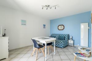 a room with a table and chairs and a couch at Cap Sur L’océan - 481 in Pornic
