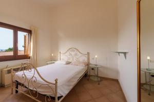 a bedroom with a bed with white sheets and a window at Casa Vacanze Fragola in Olbia