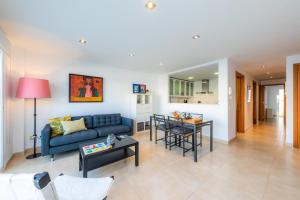a living room with a blue couch and a table at Piso Claudia in Port de Pollensa