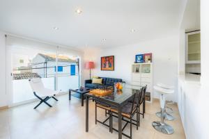 a dining room and living room with a table and chairs at Piso Claudia in Port de Pollensa