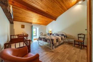 a bedroom with a bed and a chair at La Maison de Piquereau in Sauveterre-de-Guyenne