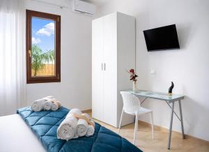 a bedroom with a blue bed and a desk at Quintessenza – Boutique Rooms in Leverano