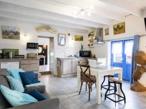 a kitchen and living room with a table and chairs at Gite Atelier La Croix Blanche in Kermaria-Sulard