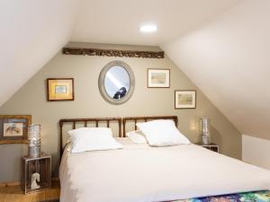 a bedroom with a large white bed in a attic at Gite Atelier La Croix Blanche in Kermaria-Sulard
